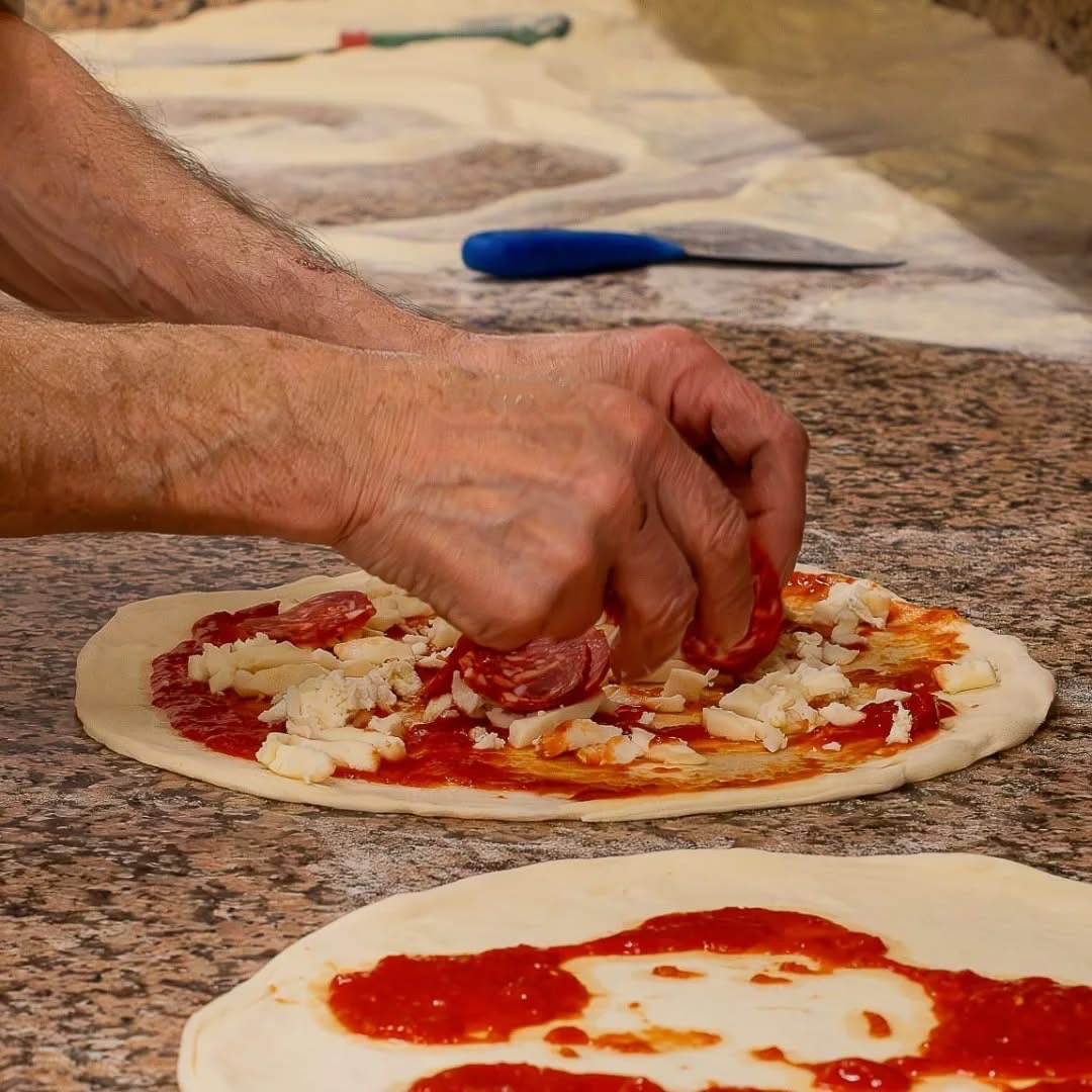 Mani che farciscono la pizza